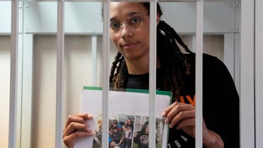WNBA star and two-time Olympic gold medalist Brittney Griner holds images standing in a cage at a court room prior to a hearing, in Khimki, outside Moscow, Russia, July 27, 2022. (Reuters)