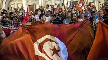 Tunisians celebrate the exit polls indicating a vote in favor of the new Constitution, in Tunis, late Monday, July 25, 2022. (AP Photo/Riadh Dridi)
