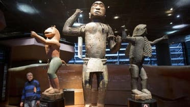  A visitor looks at wooden royal statues of the Dahomey kingdom, dated 19th century, at the Quai Branly museum in Paris, France, on November 23, 2018. (AP)