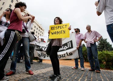 A female activist holding a placard stands amongst men during a protest against family violence near the parliament and government palace in Beirut May 29, 2011. (File photo: Reuters)