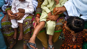 In this image taken on May 8, 2019, Pakistani women hold their HIV infected children as they gather at a house at Wasayo village in Rato Dero in the district of Larkana of the southern Sindh province. (File photo: AFP)