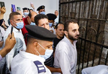 Mohamed Adel (C), the defendant in the murder of university of Mansoura student Naira Ashraf, is surrounded by guards during as he is taken out of the defender's box, after his first trial session at the Mansoura courthouse, some 145km north of Egypt's capital, on June 26, 2022. (AFP)