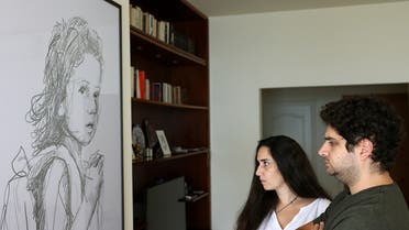 Paul and Tracy Naggear are pictured at their house in Beit Mery in the mountains east of the Lebanese capital Beirut on August 1, 2022 in front of a framed drawing for their late daughter Alexandra who was killed port blast of August 2020. (AFP)