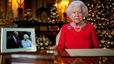 Britain's Queen Elizabeth records her annual Christmas broadcast in the White Drawing Room in Windsor Castle, next to a photograph of the queen and the Duke of Edinburgh, in Windsor, Britain, December 23, 2021. Victoria Jones/Pool via REUTERS