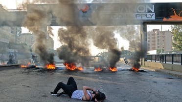 A Lebanese protester lies on a street blocked with burning tyres during a protest in the capital Beirut on November 29, 2021, as the country struggles with a deep economic crisis. (File photo: AFP)