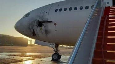 A handout picture released by the Facebook page of the Iraqi ministry of transportation, shows a damaged stationary aircraft on the tarmac of Baghdad airport, after rockets reportedly trageted the runway, on January 28, 2022. (AFP)