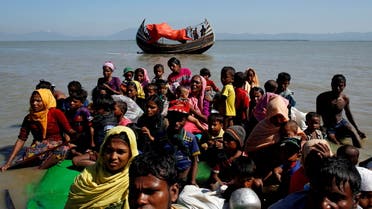FILE PHOTO: Rohingya refugees sit on a makeshift boat as they get interrogated by the Border Guard Bangladesh after crossing the Bangladesh-Myanmar border, at Shah Porir Dwip near Cox's Bazar, Bangladesh November 9, 2017. REUTERS/Navesh Chitrakar/File Photo