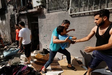 Palestinians evacuate a boy following an Israeli air strike on a house, amid Israel-Gaza fighting, in the northern Gaza Strip August 7, 2022. (Reuters)