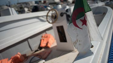 [٤:١٣ م] Joanne Serrieh An Algerian flag is displayed on a small boat used by migrants to cross The Alboran Sea, in an open-air warehouse in Almeria, southeast Spain, on October 15, 2021. (File photo: AFP)