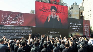 Lebanon’s Hezbollah leader Sayyed Hassan Nasrallah addresses his supporters through a screen during a religious procession to mark Ashura in Beirut’s suburbs, Lebanon, on August 9, 2022. (Reuters)