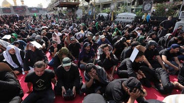 Shia Muslims react as they listen to a retelling of the story of the seventh century killing of Prophet Mohammed’s grandson Imam Hussein, commemorated throughout the 10-day mourning period of Ashura, in Iraq’s holy city of Karbala, on August 9, 2022. (AFP)