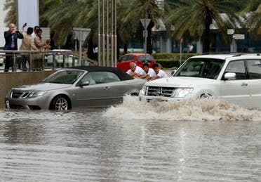 People push a car through a flooded street during a rain storm in Dubai, United Arab Emirates March 9, 2016. (File photo: Reuters)