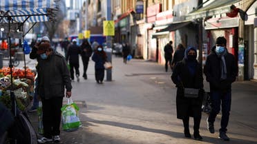 People walk past shops and market stalls, amid the coronavirus disease (COVID-19) outbreak, in east London, Britain, January 23, 2021. (Reuters)
