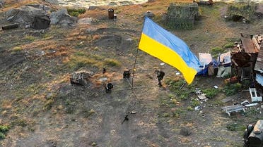 This handout picture taken and released by State Border Guard Service of Ukraine on July 7, 2022 shows the Ukrainian flag set on Bile village on Snake Island, Odessa region in Black Sea. (AFP)