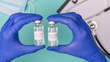 Coronavirus vaccine testing examining concept. Top above overhead view photo of doctor holding vials with masks stethoscope and clipboard isolated on blue teal background stock photo