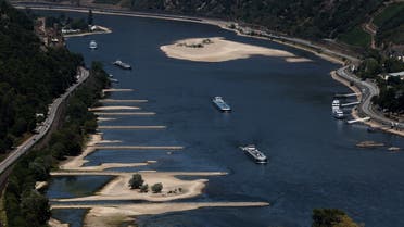 Transport vessels cruise past the partially dried riverbed of the Rhine river in Bingen, Germany, August 9, 2022. (Reuters)