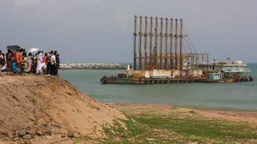 A group of Sri Lankan visitors at the new deep water shipping port watch Chinese dredging ships work in Hambantota, 240 kilometers (149 miles) southeast of Colombo, on March 24, 2010. (Reuters)
