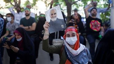 A woman holds up a poster of the late Iranian Major-General Qassem Soleimani, during a demonstration to protest remarks made during an Indian TV debate about Islam’s Prophet Muhammad and the release of 'Holy Spider' at the Cannes Festival, at Tehran University in Tehran, Iran June 10, 2022. (Reuters)