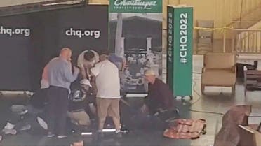 Author Salman Rushdie is helped by people after he was stabbed on stage before his scheduled speech at the Chautauqua Institution, Chautauqua, New York, U.S., August 12, 2022, in this screengrab taken from a social media video. (Reuters)
