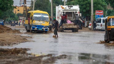 Cars and people use a flooded road following heavy rain in Sudan’s capital Khartoum, on August 13, 2022. (AFP)