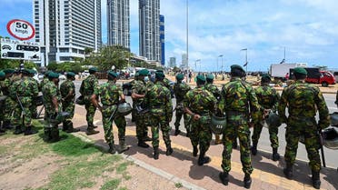 Special Task Force (STF) officers watch as demonstrators dismantle an anti-government protest camp near the Presidential Secretariat in Colombo on August 12, 2022. (AFP)
