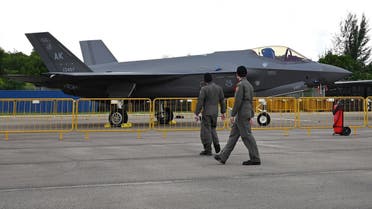 People walk past a US Marine Corps F-35A jet on static display during the Singapore Airshow in Singapore on February 15, 2022. (AFP)