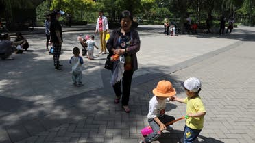 Children play next to adults at a park in Beijing, China June 1, 2021. (File photo: Reuters)