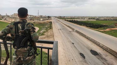 A Syrian army soldier stands overlooking a motorway in the town of Saraqib in the northwestern Idlib province on March 6, 2020, as government forces assumed control over it. (AFP)