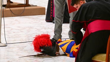 People tend to a Swiss Guard who lies on the floor after he fainted during the Pope's weekly general audience on August 17, 2022 at Paul-VI hall in The Vatican. (AFP) 