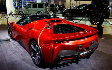 A charging cable is plugged into a Ferrari SF90 Stradale hybrid sports car during a media preview at the Auto Zurich Car Show in Zurich, Switzerland, on November 3, 2021. (Reuters)