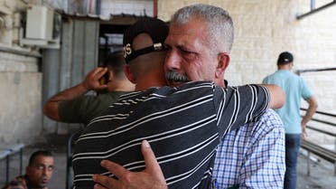 Relatives of 58-year-old Palestinian Salah Sawafta mourn his death outside a hospital morgue, who was reportedly killed in an Israeli raid in the West Bank town of Tubas, on August 19, 2022. (AFP)