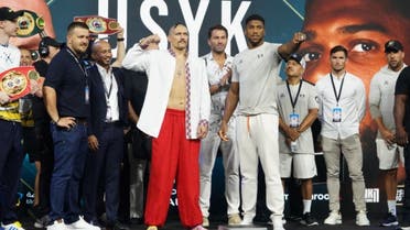 Oleksandr Usyk (left) and Anthony Joshua (right) pose at a public weigh-in event in Jeddah on August 19, 2022, ahead of their match on August 20. 