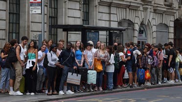 Passengers queue for busses outside Victoria Station London, on August 19, 2022, as strike action on Buses, National Rail and London Underground affects services. (AFP)
