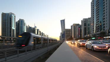 Cars wait in traffic as Dubai's new tram moves past at the Marina in Dubai on November 12, 2014. Dubai inaugurated phase one of the first tram in the Gulf region, a delayed project built by French and Belgian companies at a cost of about USD 1.25 billion. (AFP) 