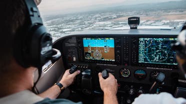 A pilot navigating a plane in the cockpit of an aircraft. (Unsplash, Kristopher Allison)