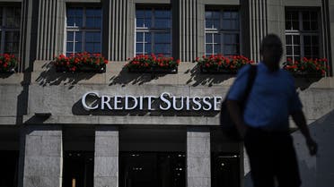 A man walks next to a branch of Swiss banking giant Credit Suisse in Bern, August 15, 2022. (AFP)