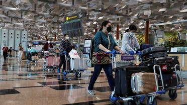 Travellers walk with their luggage at the Changi Airport in Singapore March 30, 2022. Picture taken March 30, 2022. (File photo: Reuters)