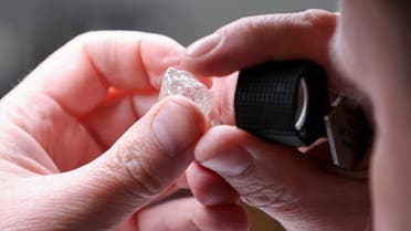 An employee holds a rough diamond at the Diamonds of ALROSA factory in Moscow, Russia, April 30, 2021. (File photo: Reuters)