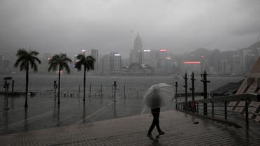 A person holding an umbrella walks in the rain at a waterfront, amid a typhoon warning on the 25th anniversary of the former British colony's handover to Chinese rule, in Hong Kong, China July 1, 2022. (Reuters)