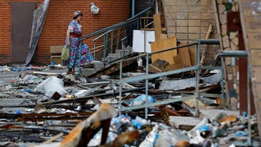 A woman walks outside an apartment building damaged in the course of Ukraine-Russia conflict in the southern port city of Mariupol, Ukraine August 21, 2022. (Reuters)