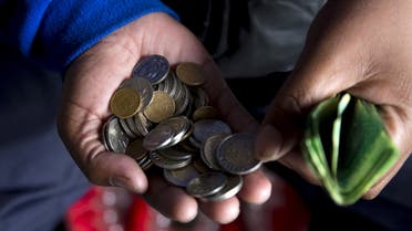 A street trader counts out change for a customer in Durban, September 8, 2015. (File photo: Reuters)
