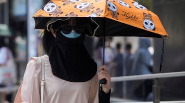 A woman wears a clothing that protect her from the sun, following the coronavirus disease (COVID-19) outbreak, amid a heatwave warning in Shanghai, China, August 23, 2022. (Reuters)