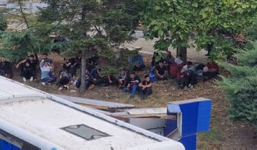 Undocumented migrants are seen at the scene of a road accident, in which two police officers were killed after being hit by a bus transporting undocumented migrants, on August 25, 2022 in Burgas on the Black Sea Coast. (AFP)