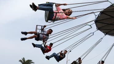 Children enjoy a swing ride during the Muslim holiday of Eid al-Fitr, which marks the end of the holy month of Ramadan, at the port-city of Sidon, Lebanon May 2, 2022. (Reuters)