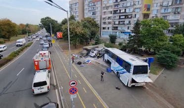 Officials work at the scene of a road accident, in which two police officers were killed after being hit by a bus transporting undocumented migrants, on August 25, 2022 in Burgas on the Black Sea Coast. (AFP)