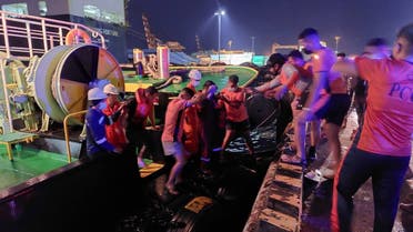 This handout photo taken and released by the Philippine Coast Guard on August 26, 2022 shows coast guard personnel assisting rescued passengers (wearing life jackets) after a ferry caught fire off the port of Batangas. (AFP)