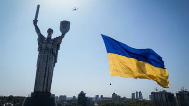 A drone carries a big national flag in front of Ukraine's the Motherland Monument in Kyiv, Ukraine, Wednesday, Aug. 24, 2022. Kyiv authorities have banned mass gatherings in the capital through Thursday for fear of Russian missile attacks. Independence Day, like the six-month mark in the war, falls on Wednesday. (AP Photo/Evgeniy Maloletka)