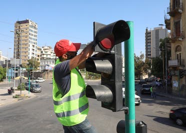 A worker at Rebirth Beirut, a Lebanese non-governmental organization, fixes a traffic light in Beirut, Lebanon May 27, 2022. (Reuters) 
