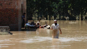 A man wades through flood waters trying to salvage his belongings following rains and floods during the monsoon season in Charsadda, Pakistan August 28, 2022. (Reuters)