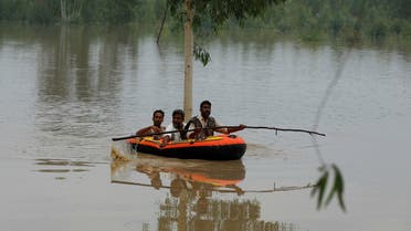 A volunteer rows an inflatable boat as he evacuates flood victims, following rains and floods during the monsoon season in Charsadda, Pakistan, August 27, 2022. (Reuters)